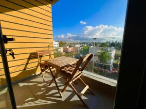 a wooden table and chair on a balcony with a view at Luxury Appartement Anoual Casablanca city in Casablanca