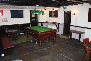 a room with a pool table and a tv at The Street Head Inn in West Burton