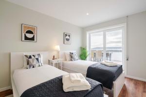 two beds in a room with a window at Bright Beachside Flat with Terrace by HostWise in Matosinhos