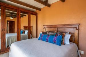 una camera da letto con un letto grande con cuscini colorati di Faro de Mita four bedroom Luxury Condo Walk to Town a Punta Mita Altre 30 foto
