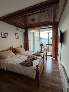 a bedroom with a large bed and a large window at Villa Srma OHRİD in Ohrid