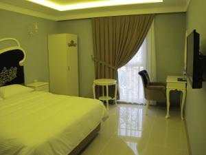 a bedroom with a bed and a tv and a window at Kaya Palas Hotel in Kırklareli