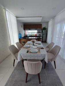 a dining room with a table and chairs and a kitchen at Arena cielo y Mar in Naranjalito