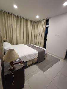 a bedroom with a bed and a table with a lamp at Arena cielo y Mar in Naranjalito