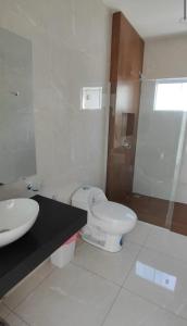 a white bathroom with a toilet and a sink at Arena cielo y Mar in Naranjalito +3 photos
