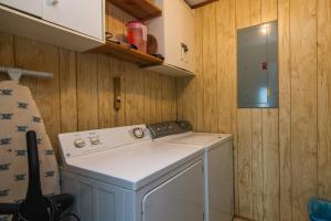 a small kitchen with a stove and a washing machine at Sea Breeze in Edisto Island +27 photos