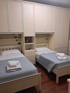 two beds in a bedroom with white cabinets at Roses house in Porto San Giorgio