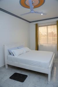 蒙巴萨FinchPAR Homes的带窗户的房间里有一张白色的床