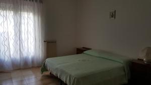 a bedroom with a green bed and a window at Tra L'Etna e il Mare in Giarre