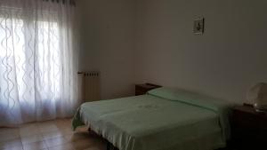 ジャッレにあるTra L'Etna e il Mareのベッドルーム(緑のベッド1台、窓付)