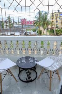 蒙巴萨FinchPAR Homes的阳台配有两把椅子和一张桌子,还有一个窗户。 更多14张照片