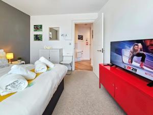 a room with two beds and a flat screen tv at The Post House One by Fortuna Property in Gloucester