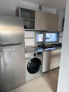 una cocina con lavadora y fregadero en Entre vientos, en La Porteña