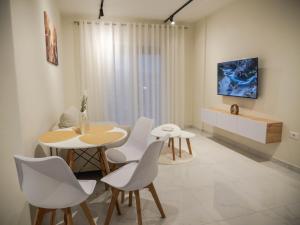 a dining room with a table and white chairs at HORIZONT Central Stay Apart-Hotel in Shkodër