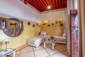 ein Zimmer mit einem Bett, einer Couch und einem Tisch in der Unterkunft Riad du Rabbin in Marrakesch + 110 Fotos