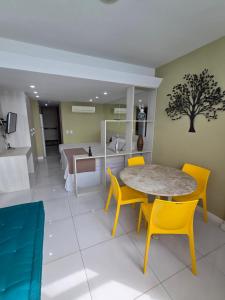 een eetkamer met een tafel en gele stoelen bij Flat Sol Victoria Marina Vista Mar in Salvador