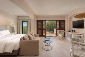 The Westin La Quinta Golf Resort & Spa, Benahavis, Marbella في مربلة: غرفة نوم مع سرير كبير وغرفة معيشة