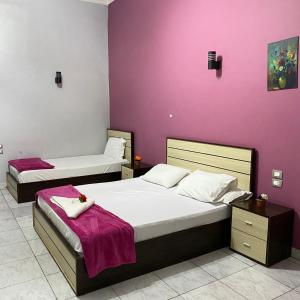 Dos camas en una habitación con paredes moradas. en Hostgram Home - Talaat Harb Square, en El Cairo