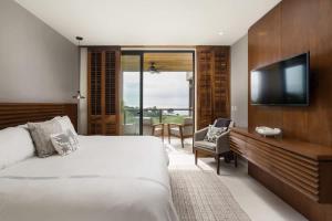 een hotelkamer met een bed en een televisie bij Tropical Oceanview Condo Punta Mita in Punta Mita