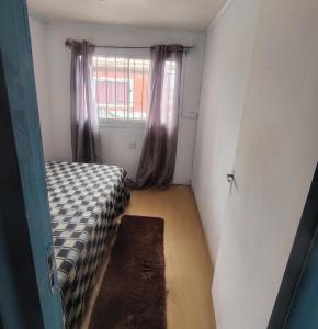 een kleine kamer met een bed en een raam bij Marina 14norte 1530 in Viña del Mar