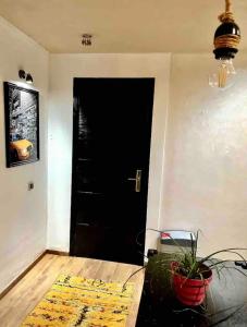 Una puerta negra en una sala de estar con una planta. en Moderne appartement in a good location, en Casablanca 8 fotos más