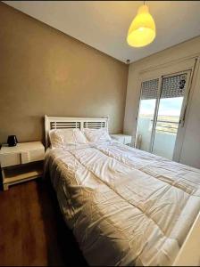 卡萨布兰卡Moderne appartement in a good location的一间卧室，有一张白色的床和一扇窗户