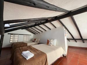 sypialnia z 2 łóżkami na poddaszu w obiekcie Aparta Hotel Eucalyptus w mieście Villa de Leyva