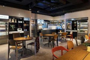 ein Restaurant mit Tischen und Stühlen und eine Bar in der Unterkunft MOXY Tokyo Kinshicho in Tokio