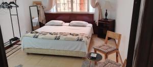 Un dormitorio con una cama y una ventana y una silla. en Chambre paisible et romantique, en Tánger 51 fotos más