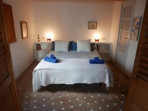 Un dormitorio con una cama con toallas azules. en Cadaqués Wonderful views central and calm tree house, en Cadaqués