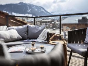 a table with two cups on top of a balcony at Novotel Megève Mont-Blanc in Megève