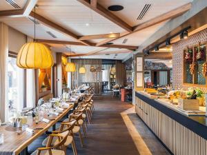 a restaurant with tables and chairs and a bar at Novotel Megève Mont-Blanc in Megève