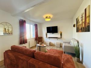 a living room with a couch and a tv at Casa Les Ponts de Cé in Les Ponts-de-Cé