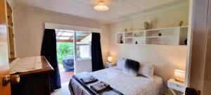 Un dormitorio pequeño con una cama y una ventana. en Quiet cul de sac, close to Abel Tasman, en Motueka