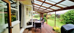 un patio exterior con pérgola y mesa en Quiet cul de sac, close to Abel Tasman, en Motueka