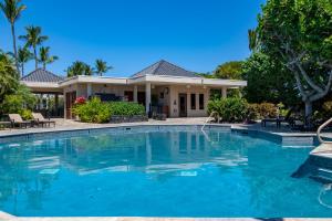 a house with a swimming pool in front of a house at Mauna Lani Point in Waikoloa +8 photos