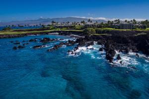 an aerial view of the ocean near a rocky coastline at Mauna Lani Point in Waikoloa