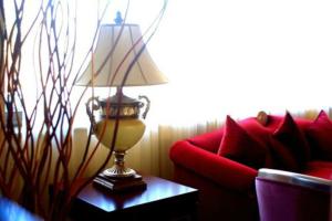 a lamp on a table next to a red couch at Cesar Palace Sousse in Sousse +160 photos