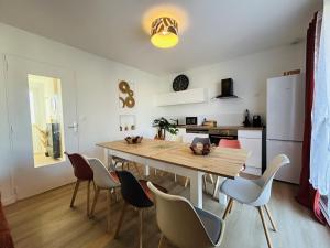 a kitchen and dining room with a wooden table and chairs at Casa Les Ponts de Cé in Les Ponts-de-Cé