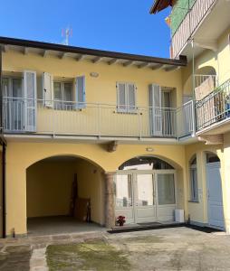 a yellow house with a balcony and a patio at A casa di Marzia - 1 in Oleggio