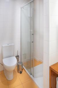 a bathroom with a toilet and a glass shower at Oporto Riverside Rooftop in Porto +21 photos