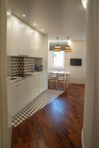 a kitchen with white cabinets and a table with chairs at Oporto Riverside Rooftop in Porto