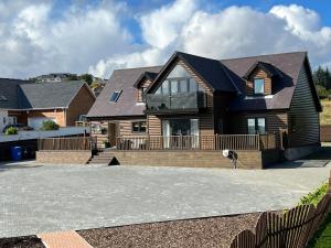 a large wooden house with a large driveway at Modern timber clad house in Stornoway