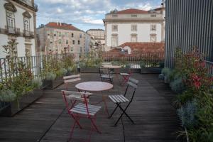 a patio with tables and chairs on a balcony at Oporto Riverside Rooftop in Porto