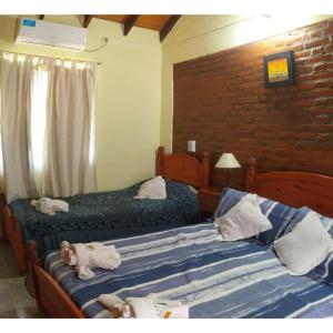 Dos camas con animales de peluche en un dormitorio en Cabañas Peñihue, en Carpintería