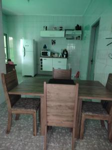 HOSTEL MEIRE pernoite في جوارولوس: مطبخ مع طاولة وكراسي خشبية وثلاجة