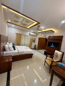 una habitación grande con una cama y un escritorio en Serene stays, en Karachi
