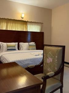 Un dormitorio con una cama, una mesa y una silla. en Serene stays, en Karachi