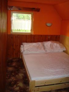 Bett in einem Zimmer mit Fenster in der Unterkunft Chata Posudov - Lipno in Frymburk