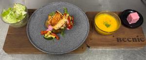 a plate of food with a sandwich and a glass of orange juice at Beenie 1 in Linz